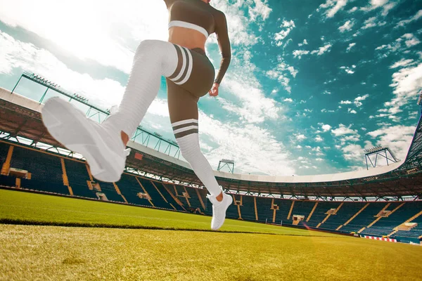 年轻的健身女性跑步运动员腿部运行在球场。体育与健康的概念. — 图库照片