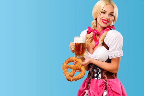 Jeune fille sexy Oktoberfest serveuse, portant une robe bavaroise traditionnelle, servant de grandes tasses à bière sur fond bleu. Espace de copie . — Photo