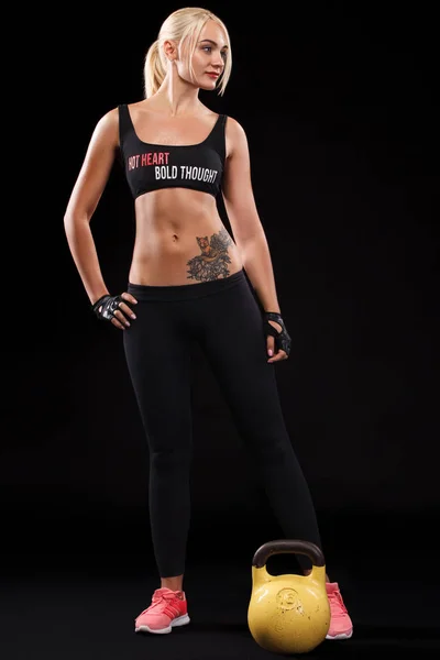 Спортивная красивая женщина делает фитнес упражнения на черном фоне, чтобы оставаться в форме. Мотивация тренировок . — стоковое фото