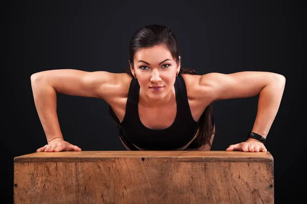 Esportiva bela mulher se exercitando em fundo preto para ficar em forma. Motivação do treino . — Fotografia de Stock