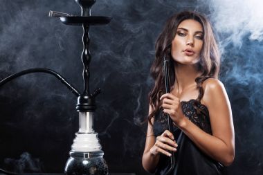 Genç, güzel kadın gece kulübü veya barda bir nargile ya da nargile duman. Sigara zevk. Seksi duman.