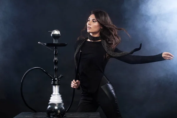 Young, beautiful woman in the night club or bar smoke a hookah or shisha. The pleasure of smoking. Sexy smoke. — Stock Photo, Image
