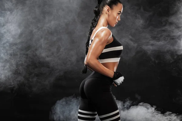 Modelo afro-americano bonito desportivo, mulher em sportwear faz exercício de fitness em fundo preto para ficar em forma — Fotografia de Stock