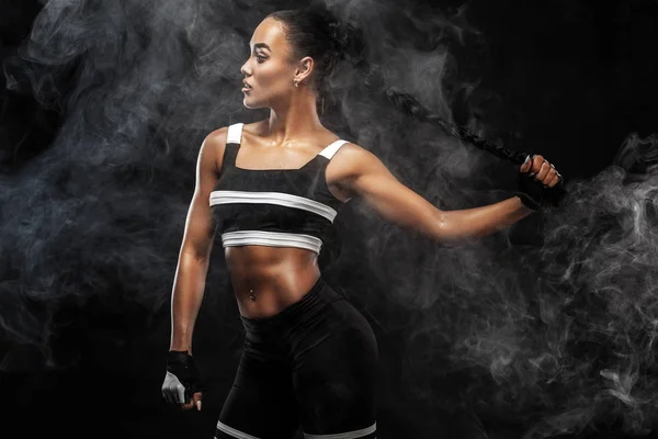 Sportos szép afro-amerikai modell, sportruházat nő teszi a fitness edzést, fekete háttér, hogy felfüggeszti az illeszkedés — Stock Fotó