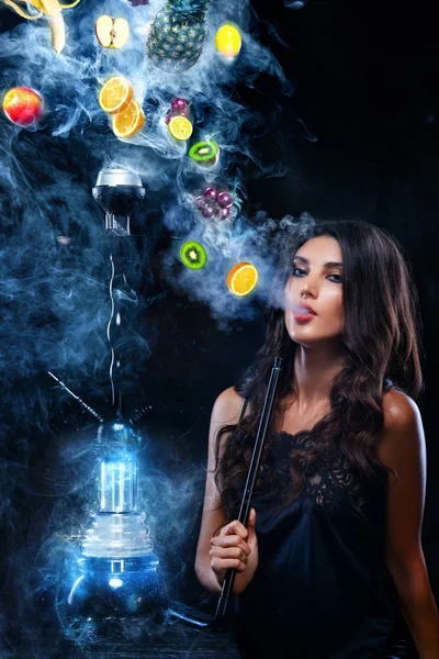 Young, beautiful woman in the night club, bar smoke a hookah or shisha. The pleasure of smoking. Fruits in the smoke. Copy space. Hookah advertisement concept. — Stock Photo, Image