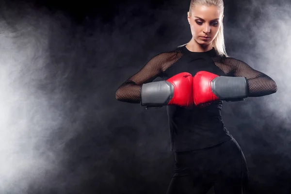 Um atlético forte, mulher boxeador, boxe no treinamento sobre o fundo preto. Conceito de boxe esporte com espaço de cópia . — Fotografia de Stock