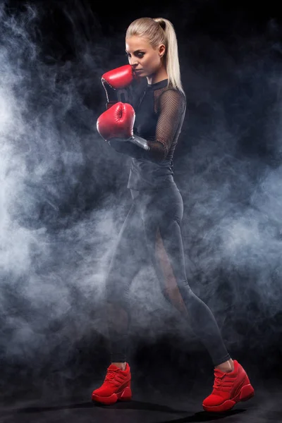 Ένα ισχυρό αθλητικό, μπόξερ γυναίκα, πυγμαχία στο εκπαίδευση σχετικά με το μαύρο φόντο. Αθλητισμός εγκιβωτίζει έννοια με αντίγραφο χώρου. — Φωτογραφία Αρχείου
