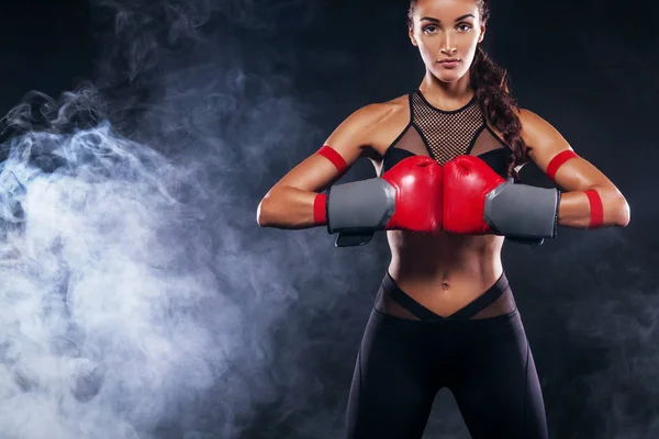 Um atlético forte, mulher boxeador, boxe no treinamento sobre o fundo preto. Conceito de boxe esporte com espaço de cópia . — Fotografia de Stock