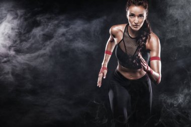 Spor, fitness ve spor motivasyon giymiş siyah arka plan üzerinde çalışan bir güçlü atletik, kadın sprinter. Runner kavramı kopya alanı ile.