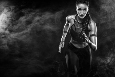 Spor, fitness ve spor motivasyon giymiş siyah arka plan üzerinde çalışan bir güçlü atletik, kadın sprinter. Runner kavramı kopya alanı ile.