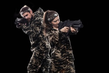 Siyah arka plan üzerine izole maskeli asker ağır silahlı. Spor Oyunları Top ve lazer etiketi boya.