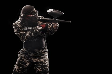Siyah arka plan üzerine izole ağır silahlı maskeli asker. Spor Oyunları Top ve lazer etiketi boya.