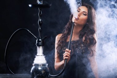 Genç, güzel kadın gece kulübü veya barda bir nargile ya da nargile duman. Sigara zevk. Seksi duman.