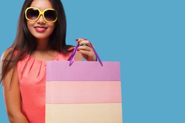 Alışveriş holding çanta ve telefon üzerinde mavi arka plan siyah Cuma tatil izole mutlu Asyalı kadın. Satılık reklamlar için kopya alanı.