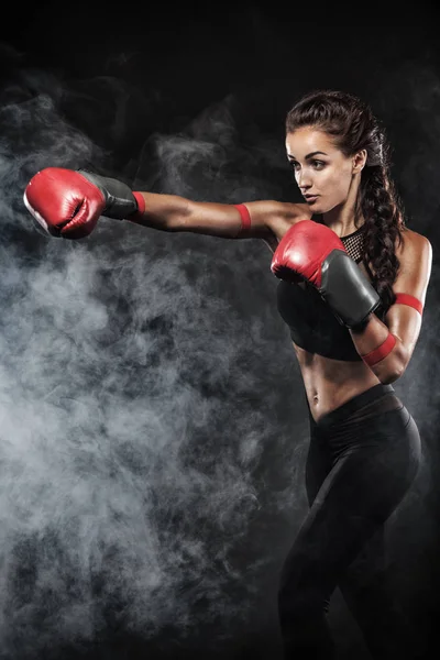 Um atlético forte, mulher boxeador, boxe no treinamento sobre o fundo preto. Conceito de boxe esporte com espaço de cópia . — Fotografia de Stock