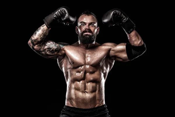 Боксер с татуировкой в боксёрских перчатках празднует чистую победу. Концепция спорта на черном фоне . — стоковое фото
