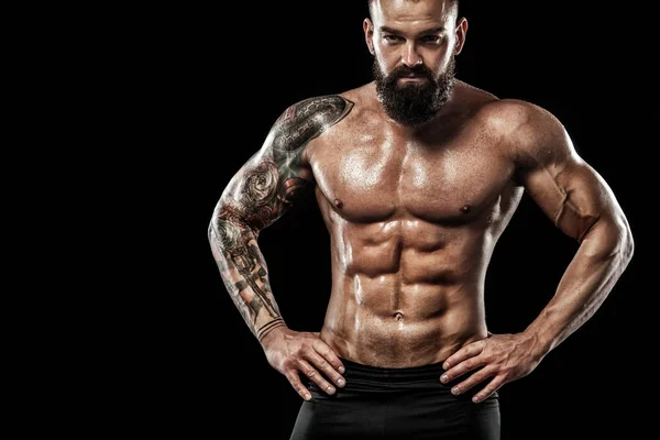 Dövme ile kot giyiyor poz uygun yakışıklı. Siyah arka plan üzerine izole spor ve moda kavramı.