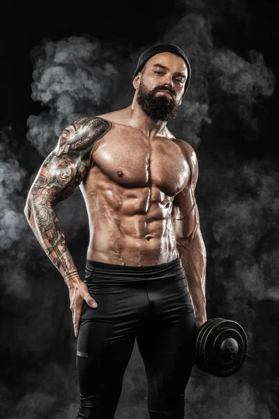 Spor salonundaki halterle spor yapan kaslı genç sporcu.