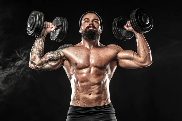 Muscular young fitness sports man workout with dumbbell in fitness gym — Stock Photo, Image