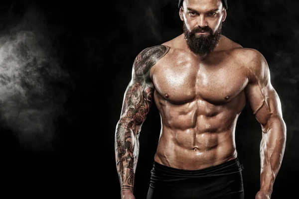 Spor salonundaki halterle spor yapan kaslı genç sporcu.