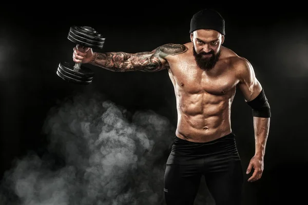 Gespierde jonge sport man fitnesstraining met barbell in fitness gym — Stockfoto