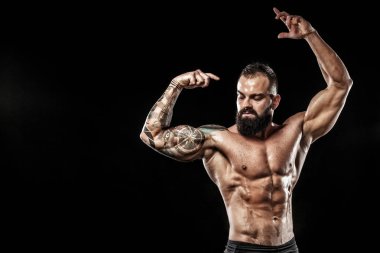 Dövme ile kot giyiyor poz uygun yakışıklı. Siyah arka plan üzerine izole spor ve moda kavramı.