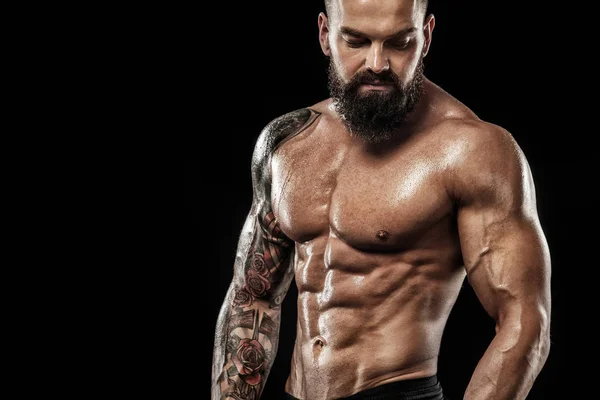 Dövme ile kot giyiyor poz uygun yakışıklı. Siyah arka plan üzerine izole spor ve moda kavramı.