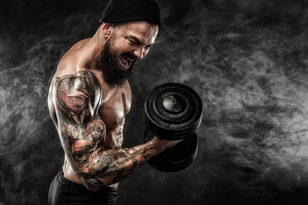 Mięśniowy młody fitness sport człowiek trening z hantlami w siłowni — Zdjęcie stockowe