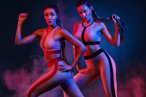Um atlético forte, mulheres em fundo de cor vestindo na moda sportswear, fitness e motivação desportiva . — Fotografia de Stock
