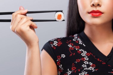 Suşi ve gri bir arka plan üzerinde rulo ile Japon kimano Asyalı kadın portre portre. Kopya alanı.