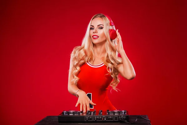 Poster for DJ party. Portrait of sexy woman with deck playing music on red christmas background — Stock Photo, Image