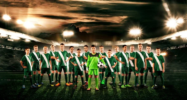 Soccer team. Kids - future champions. Boys in football sportswear on stadium with ball. Sport concept.