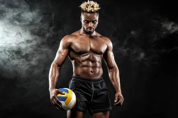 Портрет афро-американського спортсмена, гравця у валлійський футбол з м'ячем на чорному тлі. Вмістити молодого чоловіка в спортивний одяг тримає м'яч . — стокове фото