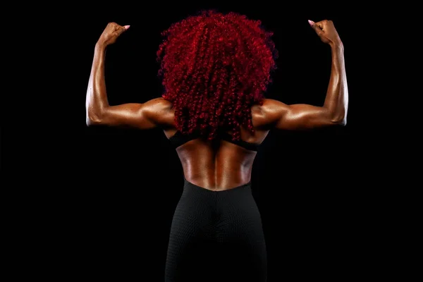 Una donna forte atletica su sfondo nero che indossa abbigliamento sportivo, fitness e motivazione sportiva. Concetto sportivo con spazio copia . — Foto Stock