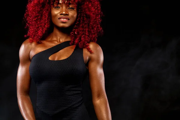 En stark atletisk kvinna på svart bakgrund bär i sportkläder, fitness och sport motivation. Sport koncept med kopia utrymme. — Stockfoto