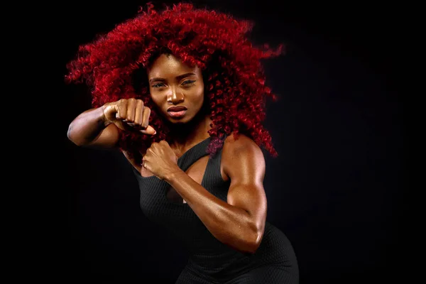 Uma mulher atlética forte no fundo preto vestindo em roupas esportivas, fitness e motivação esportiva. Conceito de esporte com espaço de cópia . — Fotografia de Stock