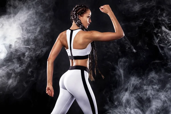 Una donna forte atletica su sfondo nero che indossa abbigliamento sportivo bianco, fitness e motivazione sportiva. Concetto sportivo con spazio copia . — Foto Stock