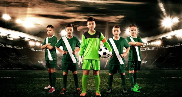 Crianças - campeões de futebol. Rapazes em sportswear futebol no estádio com bola. Conceito de esporte com equipe de futebol . — Fotografia de Stock