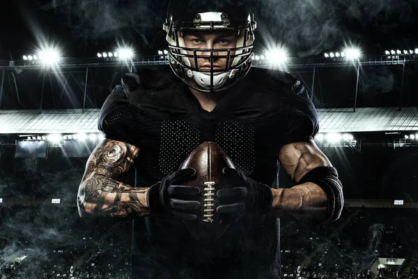 Sport concept. American football sportsman player holding ball on stadium. — Stock Photo, Image