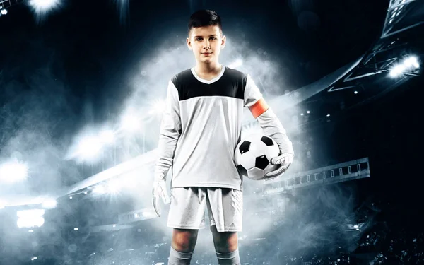 Kids - soccer champion. Boy goalkeeper in football sportswear on stadium with ball. Sport concept. — Stock Photo, Image