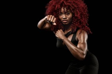 Sportif güzel Afro-Amerikan modeli, eşofman kadında fit kalmak için siyah arka plan egzersiz fitness yapar