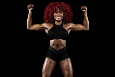 Sportif güzel Afro-Amerikan modeli, eşofman kadında fit kalmak için siyah arka plan egzersiz fitness yapar