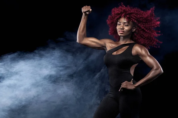 Sportif güzel Afro-Amerikan modeli, eşofman kadında fit kalmak için siyah arka plan egzersiz fitness yapar — Stok fotoğraf