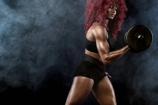Sportig vacker kvinna med hantlar gör fitness träning på svart bakgrund för att hålla sig i form — Stockfoto