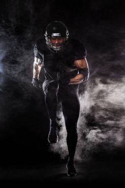 Amerikan futbolu sporcu oyuncu siyah arka plan üzerine izole