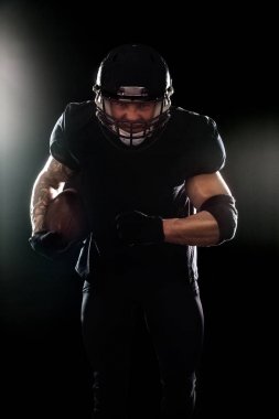 Amerikan futbolu sporcu oyuncu siyah arka plan üzerine izole