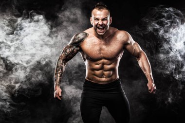 Dövme ile kot giyiyor poz uygun yakışıklı. Siyah arka plan üzerine izole spor ve moda kavramı.