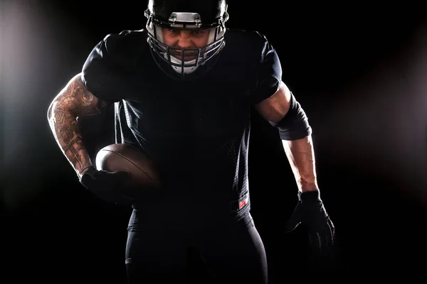 Desportista de futebol americano jogador isolado em fundo preto — Fotografia de Stock