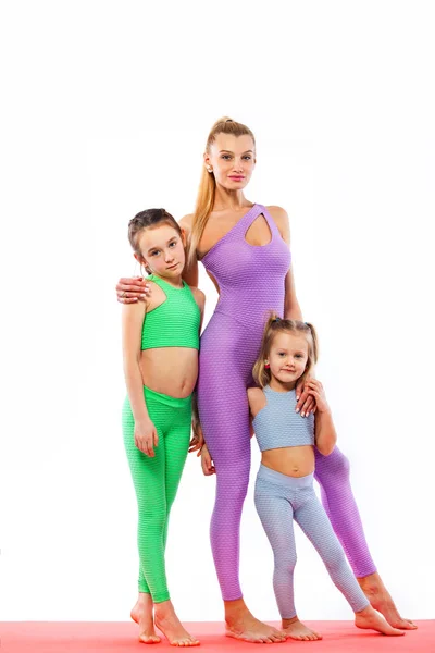 Fitness aile. Hatha yoga. Genç öğretmen anne ve kızı birlikte jimnastik egzersiz. Beyaz arka plan üzerinde izole. Aile bak. — Stok fotoğraf