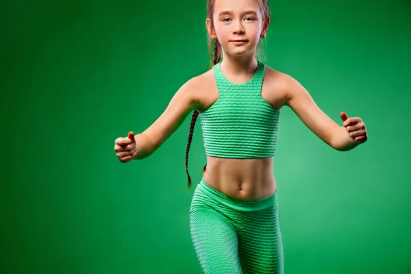 Menina fazendo exercícios de fitness no fundo verde — Fotografia de Stock